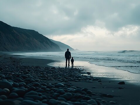 A father and son silhouette on a beach.