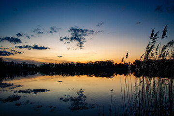 Sonnenunterng am See mit dramatischen Himmel 