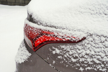 Tail light of a modern car covered in snow