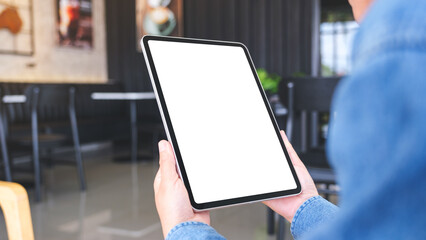 Mockup image of a woman holding digital tablet with blank desktop screen in cafe