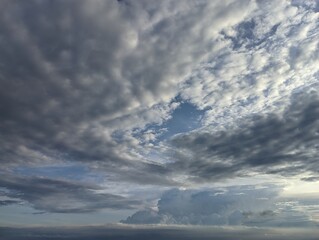 Obraz premium Dramatic Cloudscape with a Glimpse of Blue Sky. A captivating image of a dynamic sky filled with varying shades of gray and white clouds.