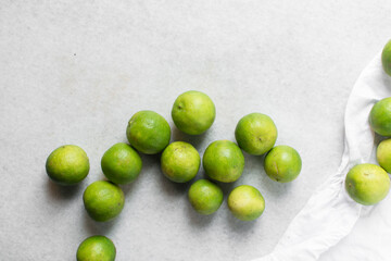Overhead view of green limes on a white marble countertop, top view of organic limes on a white background