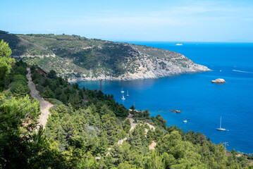 Panoramic view of the Magnet mount, a magnetite deposit where the famous iron mines of Elba island are located with yacht and sailboats on the fresh blue waters of the cape cod named Capoliveri