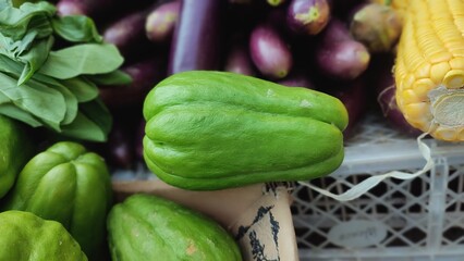 Chayote or Sechium edule sale in traditional market. Vegetables background
