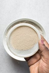 Overhead view of instant yeast on a white tray, yeast granules for baking bread