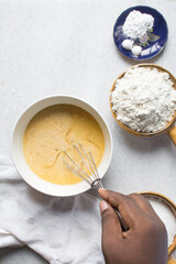 Whisking eggs and sugar together until pale, mixing eggs and sugar by hand, process of making a cake