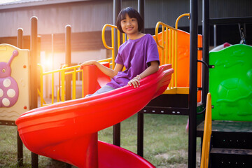 Joyful Children Sliding Down A Playground Slide During A Sunny Afternoon