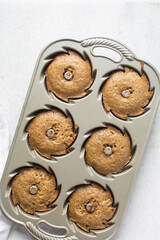 Overhead view of mini bundt cakes in a silver baking pan, top view of bundtlette cakes in a baking pan