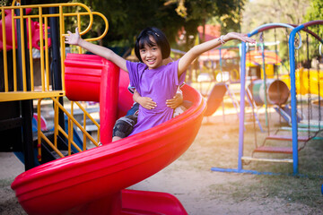 Joyful Children Sliding Down A Playground Slide During A Sunny Afternoon