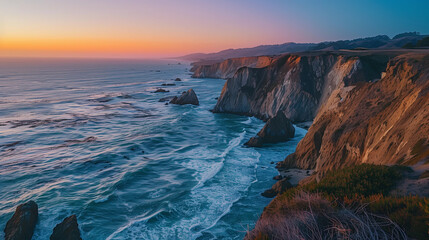 A coastal landscape at twilight, cliffs overlooking a deep blue sea