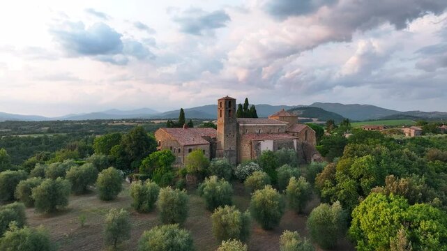 Avvicinamento progressivo con drone all'abbazia di Sovana, stile romanico circondato da ulivi, Toscana, 4k