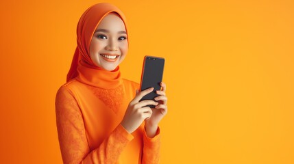 Smiling Woman in Orange Holding Smartphone