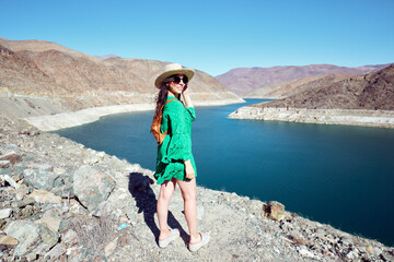 Naklejka premium Beautiful latin tourist woman posing outdoors in the Huasco valley with a damn in the background