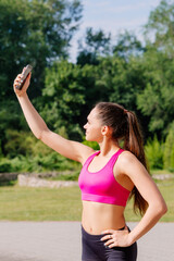 Modern young woman with cellphone making pause during jogging exercise.