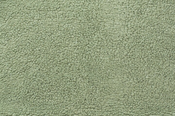 Green cuddle teddy bear fabric as background, top view © Liami