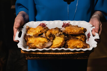 Woman holding french meat with melted cheese in white dish