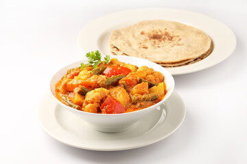 Mix vegetable curry - Indian main course recipe contains Carrots, cauliflower, green peas and beans and served in ceramic ware with Chapati ,Indian flat bread , roti