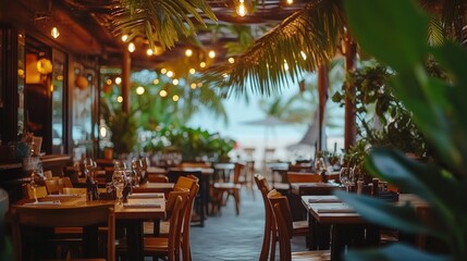 Obraz premium Outdoor restaurant with tables and chairs, a view of the beach, and string lights.