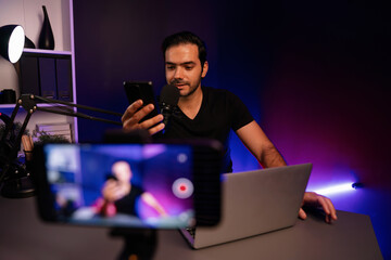 Broadcaster talking to listener on live streaming online with blurred screen, reading comment on...