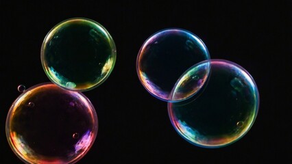 Vier gro&szlig;e bunte Seifenblasen fliegen in der Luft, dunkler Hintergrund