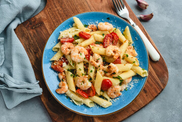 Penne pasta with shrimps and cherry tomatoes in butter and garlic sauce