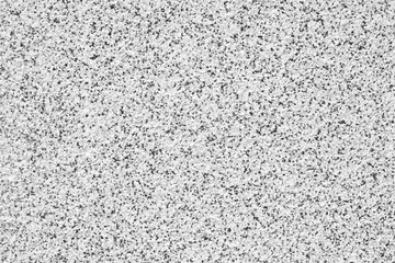 A white and gray stone wall with a lot of small white and gray stones. The wall is very plain and simple