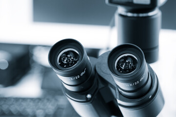 Two microscope eyepieces close-up in a laboratory
