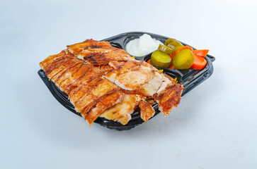 Close up of chicken shawarma meal with lettuce, tomato and onion on white background.
