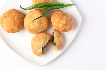 Kachori, green chilly, kachori is a spicy snack from India also called  kachauri and kachodi. Favorite Tea time snacks
served in a ceramic plate