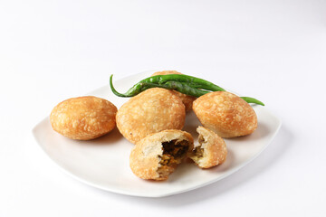 Kachori, green chilly, kachori is a spicy snack from India also called  kachauri and kachodi. Favorite Tea time snacks
served in a ceramic plate