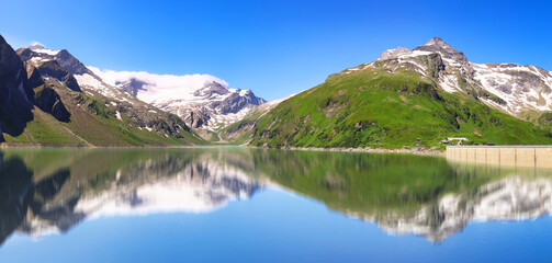 Austria - green mountain lake with dam near Grossglokner. Mosserboden dam and alpine peaks in the background .Panorama view of Stausee Wasserfallboden, Hohe Tauern Alps - Kaprun