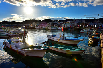 Japanese local harbour in fisherman village of Wakayama in the evening. Small fishery boat floating close to the bank.