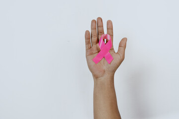 Hand holding pink ribbons on white background. World epilepsy day. Alzheimer's disease, Pancreatic...
