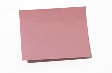 Fototapeta premium Blank Pink Sticky Note on White Background, Representing Space for Messages, Reminders, or Creative Thoughts in Minimalist Design