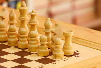 A wooden chess board with a white king and a black knight