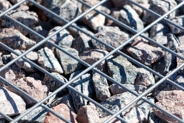 A close up of a rock field with a metal fence