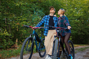 Naklejka premium Couple while riding bicycles looking at the nature around