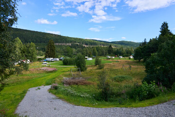 A scenic parking area designed for RVs, set in a natural landscape perfect for summer travel. This spot is ideal for vacationers seeking outdoor experiences and relaxation in nature