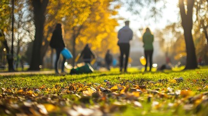 Fototapeta premium Backlit autumn park scene with people walking.