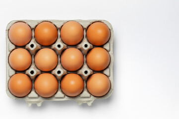 Brown eggs in a carton, isolated on a white background.