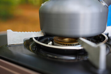 Close-up of a camping kettle on a gas stove in forest