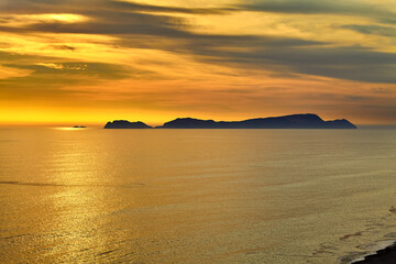 Fototapeta premium As the sun sets over San Lorenzo Island, the view from Miraflores becomes pure magic .The island silhouettes against a sky ablaze with color, while the ocean whispers of infinite horizons. 