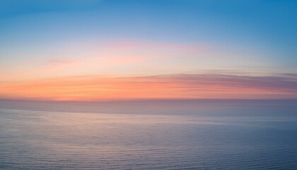 Obraz premium A serene sunset over the ocean, with soft pink and orange hues painting the sky.
