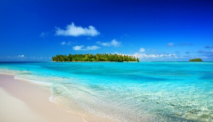 Fototapeta premium A pristine white sand beach stretches out to turquoise waters and a lush tropical island in the distance.