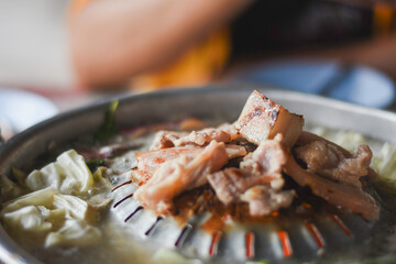 close-up of a cooking setup, likely for a Korean BBQ or similar style of cooking.