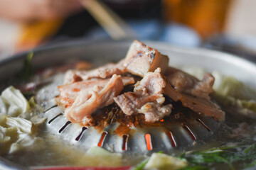 close-up of a cooking setup, likely for a Korean BBQ or similar style of cooking.