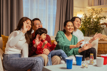 laughing, parents, relaxed, happiness, family, enjoying, happy, funny, celebrate, celebration. A family of five is sitting and watching a movie. Scene is happy and relaxed, as everyone is enjoying.