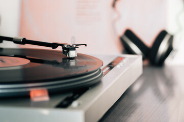 Headphones and vinyl turntable close-up.. Close-up of a cartridge head on a vinyl record, analog retro music, vinyl disc collecting, vintage equipment
