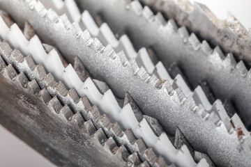 Close-up of jigsaw blades showing different tooth patterns for cutting wood and metal, illustrating tool versatility.