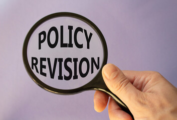 Policy revision symbol. Concept word Policy revision on magnifying glass. Businessman hand. Beautiful purple background. Business and Policy revision concept. Copy space